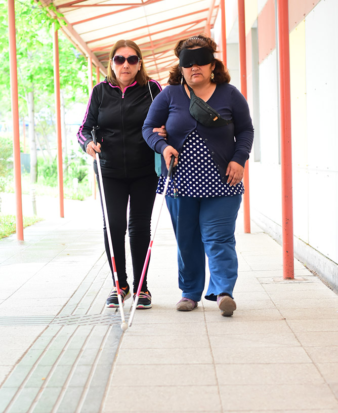 mujeres caminando con bastón de ayuda