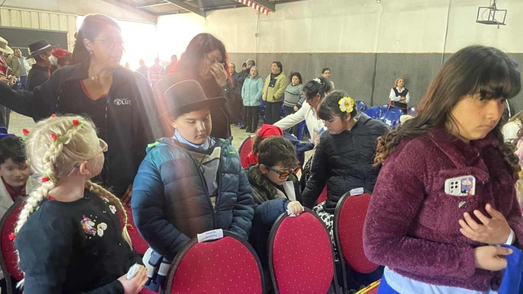 Público asistente a la fiesta del 18, se divisan niños y niñas con discapacidad visual y dos profesoras.