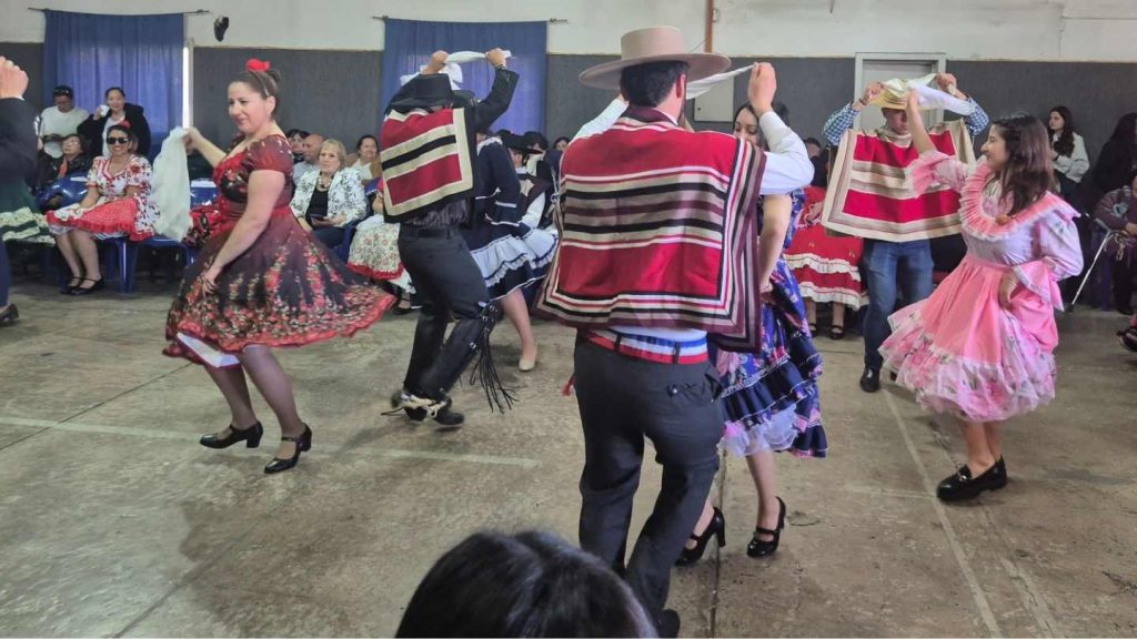 Baile de cueca, se divisan 3 parejas bailando con pañuelos.