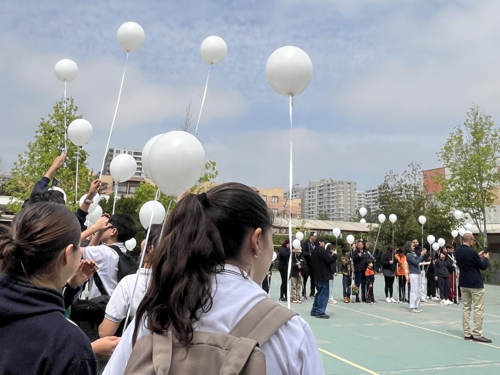 Muchas personas soltando globos blancos al cielo