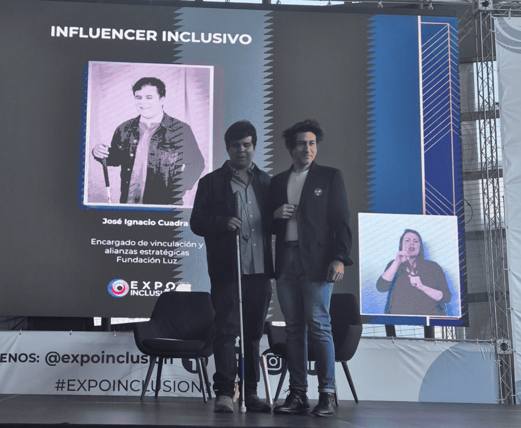 José Cuadra en el escenario mostrando su premio de Influencer del año junto a Cristian Galleguillos de Fundación Luz.