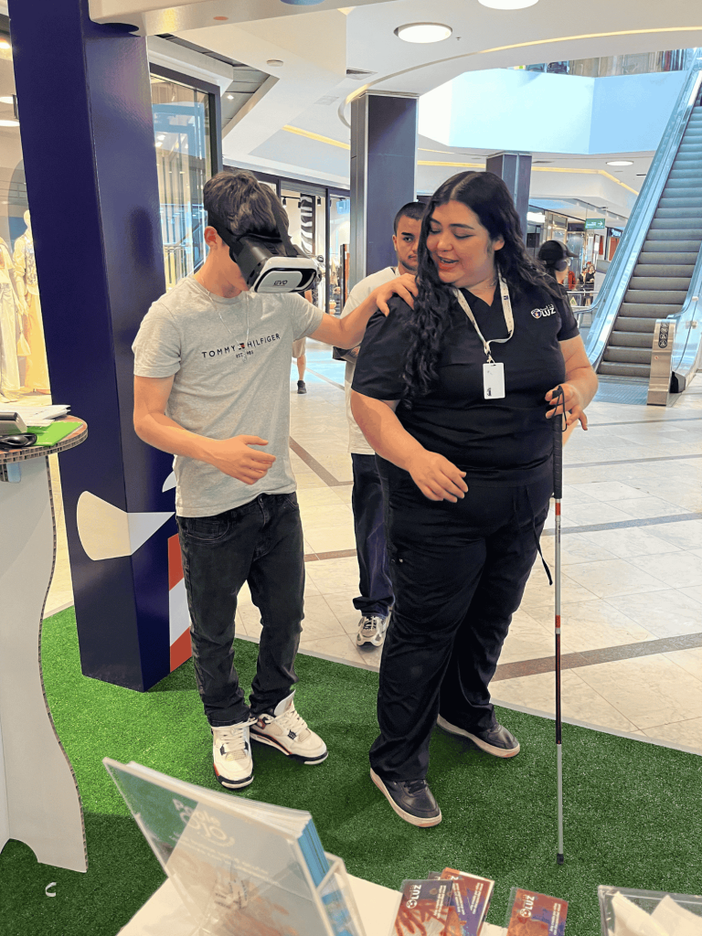 Terapeuta de Fundación Luz guiando a joven con lentes de realidad virtual.